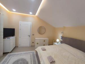 a large bedroom with a bed and a television at Zafir Apartment in Korçë