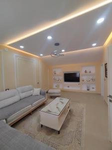 a living room with a couch and a tv at Zafir Apartment in Korçë +6 photos