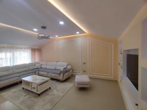 a living room with a couch and a tv at Zafir Apartment in Korçë