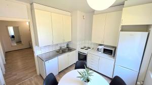 una cucina con un frigorifero bianco e un tavolo di Villa Ruths Stay Polle a Kouvola