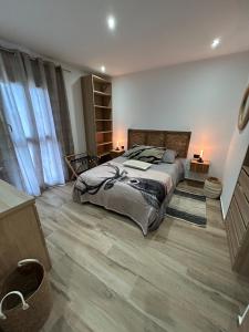 a bedroom with a large bed and wooden floors at Villa Casa Luma in Balaruc-les-Bains