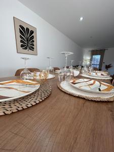 a table with wine glasses and plates on it at Villa Casa Luma in Balaruc-les-Bains