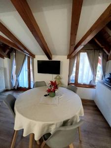een eetkamer met een witte tafel en stoelen bij Appartamento Vittoria in Cles