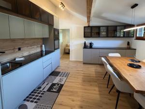 a kitchen with a wooden table and a dining room at Deine Auszeit mit Alpen- und Kanderblick in Kandergrund