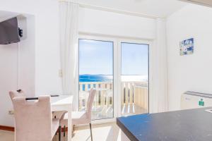 a kitchen with a table and a view of the ocean at Apartments Toni 2000 in Podstrana