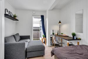 a living room with a couch and a table and a desk at Oddernesveien 7 in Kristiansand