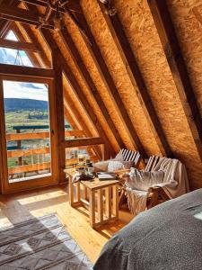a room with a bed and a table and a window at Vikendica Pino in Han Pijesak