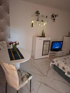 a living room with a table and a tv at Studio apartman Franka in Vukovar