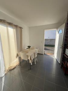 a white dining room with a table and a window at Maison entière avec jardin , Proche Bordeaux, Rocade et Arkéa Arena in Bouliac