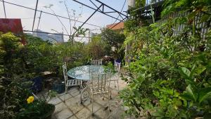 a patio with a table and chairs in a garden at Sky Garden Home in Dhaka