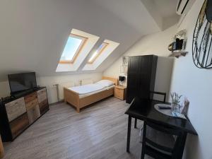 a small attic room with a bed and a desk at Pension Lizzi in Vienna