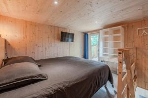 a bedroom with a bed in a wooden wall at Le KuboLodge - Tiny House premium in Jacou