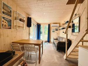 a living room with a table and a couch at Le KuboLodge - Tiny House premium in Jacou
