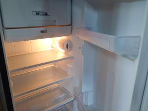 a white refrigerator with its door open with its at Cabaña lago Río Celeste in El Achiote