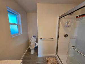 a bathroom with a shower and a toilet and a window at Lakefront Retreat • Private Yard + Fireplace in Clearlake Oaks +21 photos