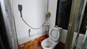 a bathroom with a toilet with a phone on the wall at Sky Garden Home in Dhaka +26 photos