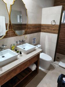a bathroom with a sink and a toilet and a mirror at Six Pillars Resort in Bastimentos