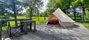 Tenda su una terrazza in legno con tavolo di Domaine de Calabel a Pouylebon