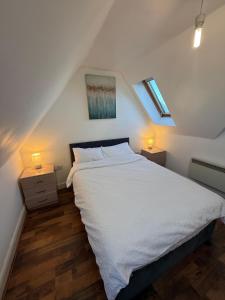 a bedroom with a white bed with two night stands at Guildford Court Apartment Colchester in Colchester