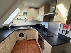 a kitchen with a sink and a washing machine at Guildford Court Apartment Colchester in Colchester