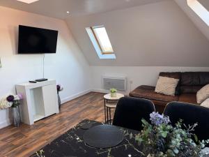 a living room with a couch and a tv at Guildford Court Apartment Colchester in Colchester