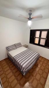 una camera da letto con un letto e un ventilatore a soffitto di Ubatuba Sport House a Ubatuba Altre 7 foto