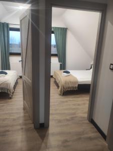 a room with two beds and a door with two beds at Wigierska Piertówka in Leszczewo