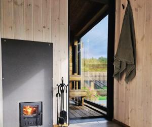 a door to a porch with a view of a deck at Kursīšu namiņš in Skulte +50 photos