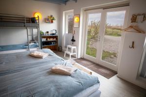een slaapkamer met 2 bedden en een glazen schuifdeur bij Mosters Bed & Breakfast in Guldborg
