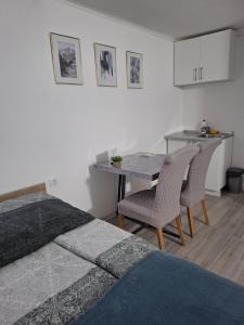 een slaapkamer met een bed, een tafel en stoelen bij Fly & Stay Apartments in Laktaši +22 foto's