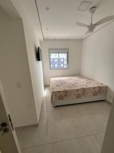 a bedroom with a bed and a window at Refúgio Brisa e Mar in Mongaguá +5 photos