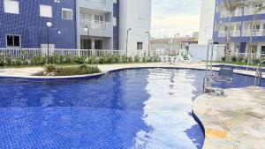 a large swimming pool in front of a building at Refúgio Brisa e Mar in Mongaguá