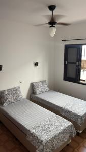 due letti uno accanto all'altro in una stanza di Ubatuba Sport House a Ubatuba