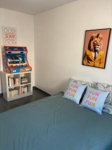 een slaapkamer met een blauw bed en een videogame bij Maison entière avec jardin , Proche Bordeaux, Rocade et Arkéa Arena in Bouliac