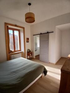 a bedroom with a bed and a window and a door at Gradine et Boucharde in Le Monastier sur Gazeille