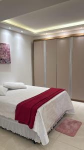 una camera da letto con un grande letto con una coperta rossa sopra di Luxo Urbano 2, 3 ou 4 quartos a Campinas Altre 67 foto