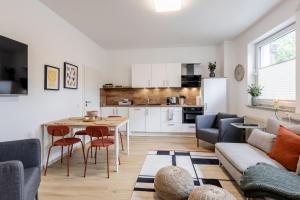 a living room with a table and a kitchen at Ems Suite 1 in Warendorf