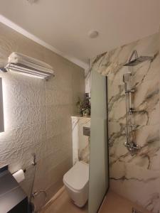 a bathroom with a toilet and a marble wall at Petra Masterpiece in Wadi Musa +138 photos