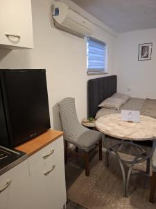een kleine kamer met een keuken en een tafel met een tv bij Fly & Stay Apartments in Laktaši