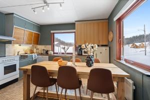 a kitchen with a wooden table and chairs at Nordnorge Self-Check-In in Majavatn +40 photos