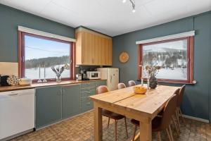 a kitchen with a wooden table and a dining room at Nordnorge Self-Check-In in Majavatn