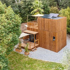 a wooden building with a deck and a table at Le KuboLodge - Tiny House premium in Jacou