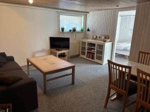 een woonkamer met een bank en een tafel bij 6 person Holiday Inn in Hvide Sande +5 foto's