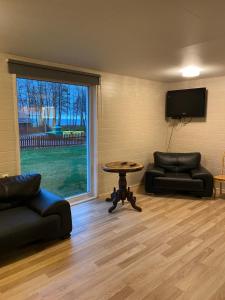 a living room with two couches and a table and a tv at Vesilinnu 2 in Aabla