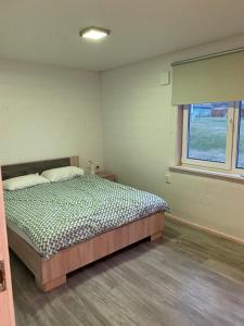 a bedroom with a bed and a window at Vesilinnu 2 in Aabla