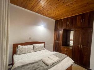 a bedroom with a bed with two towels on it at Toiwo Residence Arusha in Arusha