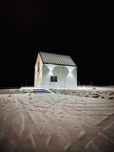 a white barn in the snow at night at Stodoła Na Widoku z Balią in Radków
