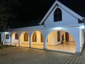 a white house with a courtyard at night at Toiwo Residence Arusha in Arusha