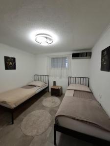 twee bedden in een kamer met twee tapijten bij Fly & Stay Apartments in Laktaši