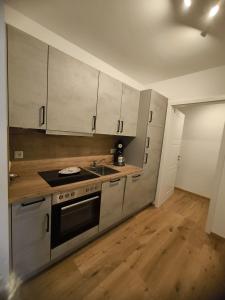 a kitchen with stainless steel appliances and wooden floors at SeeZeitApartments Whg 28 in Lembruch